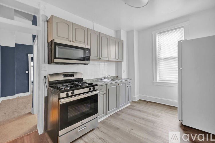 A kitchen with a stove, oven, microwave, and cabinets.
