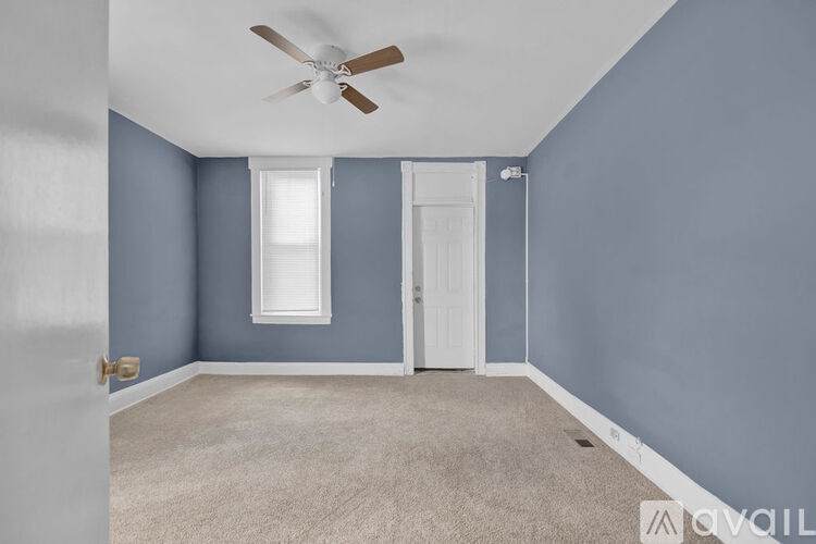 A room with blue walls and a ceiling fan.