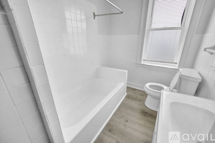 A white bathroom with a tub, toilet, and sink.