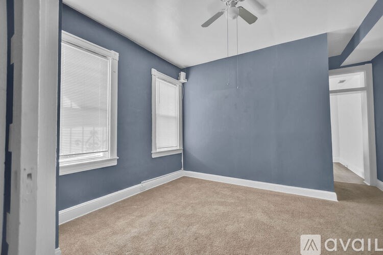 A room with blue walls and a ceiling fan.