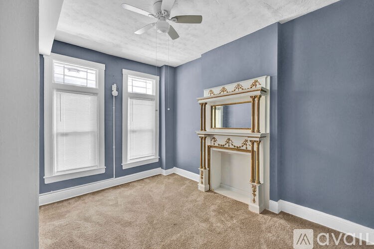 A room with a fireplace and a ceiling fan.