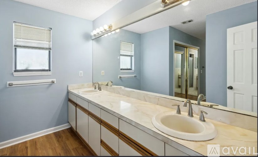 A bathroom with a white sink and a mirror.