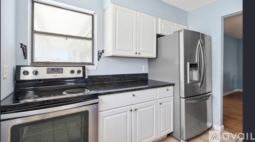 A kitchen with white cabinets and a black stove top oven.