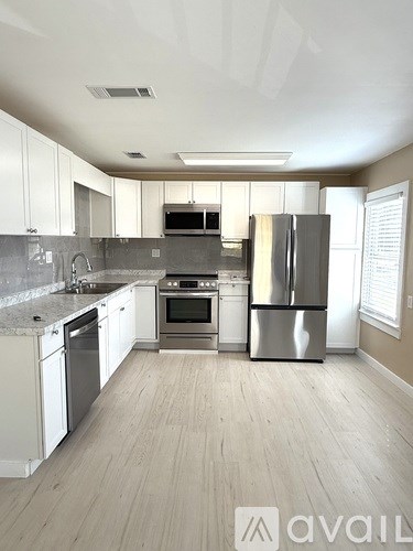 A kitchen with white cabinets and stainless steel appliances.