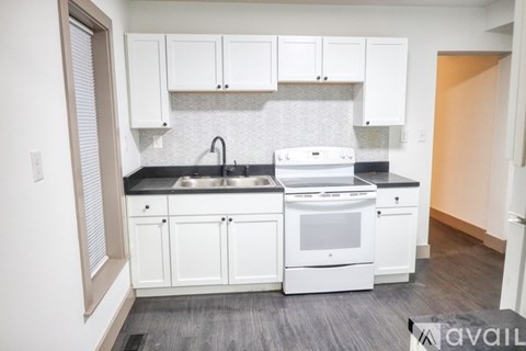 A kitchen with white cabinets and appliances.