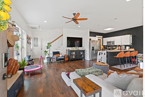 A living room with a white couch and a pink trampoline.
