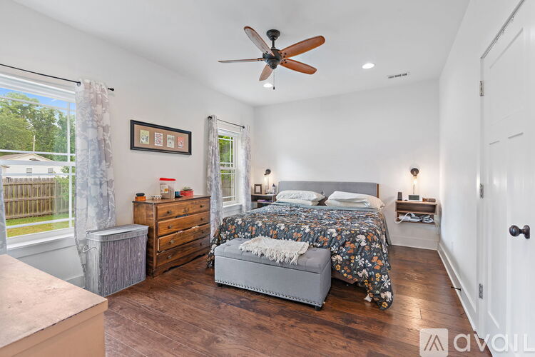 A bedroom with a bed, dresser, and window.