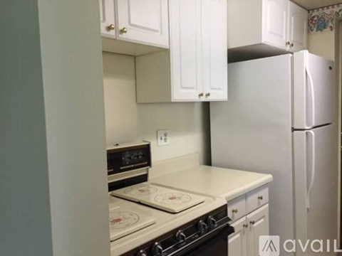 A kitchen with white cabinets and a stove top oven.