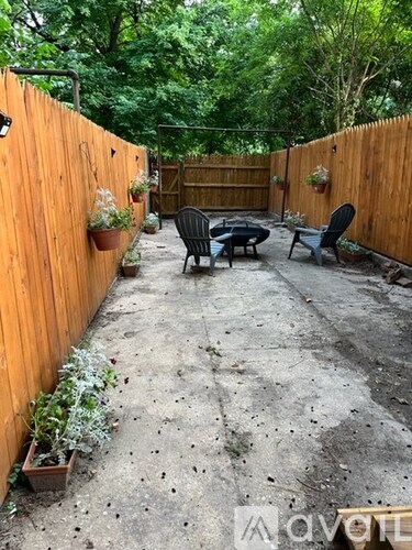 A backyard with a wooden fence and a patio table.