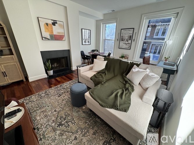 A long hallway with a fireplace and wooden floors.