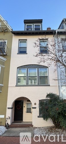 Two cars parked in front of a two-story building.