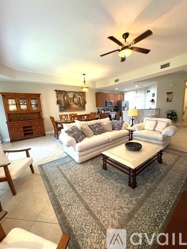 A living room with a white couch and a rug.