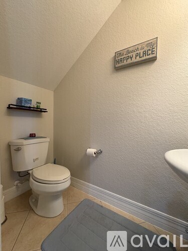 A bathroom with a toilet and a sign that says "Happy Place".