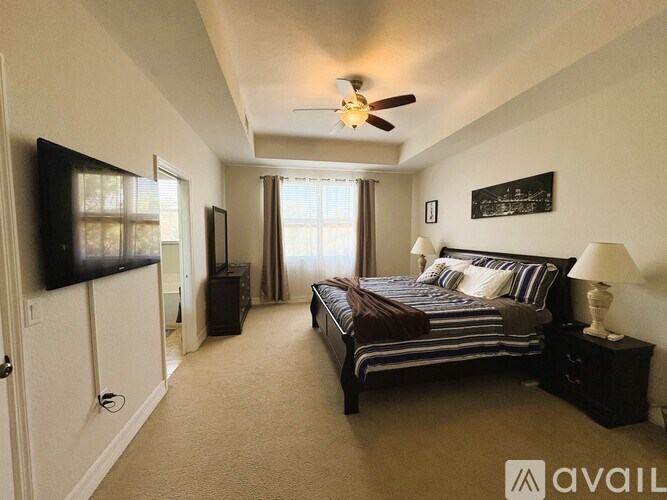 A bedroom with a bed, dresser, and television.