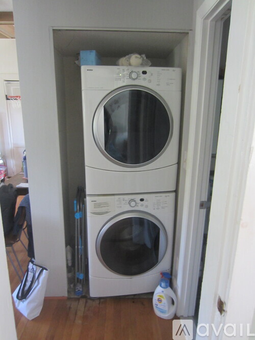 A stack of two washing machines in a small room.