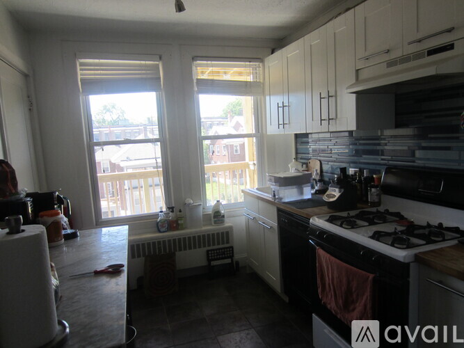 A kitchen with a stove, sink, and window.