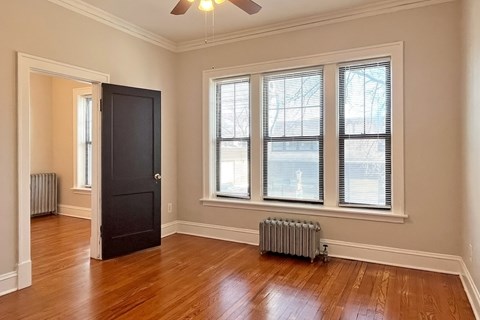 A room with a black door and a ceiling fan.