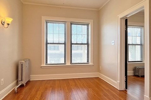 A room with wooden floors and two windows.