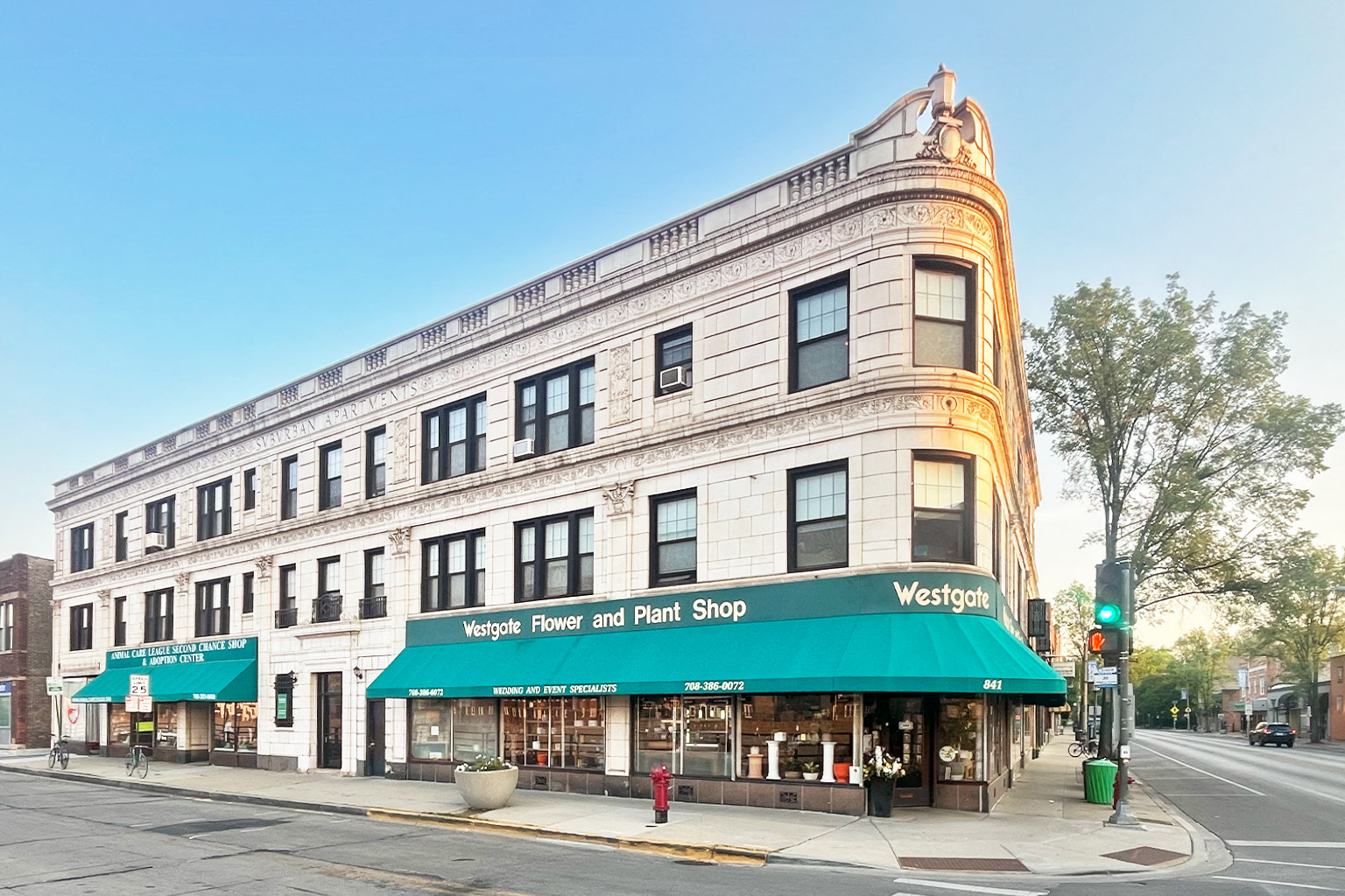 A street view of a building with a green awning that says "Vergil's Flower and Plant Shop".