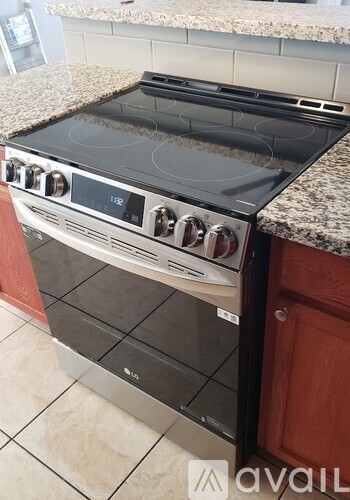 A modern stove top oven with a digital display and control knobs.