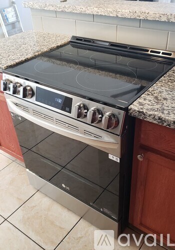 A modern stove top oven with a digital display and control knobs.
