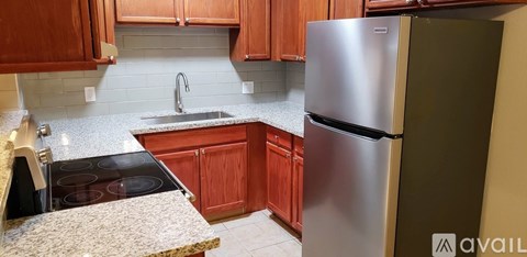 A kitchen with a stove top oven, sink, and refrigerator.