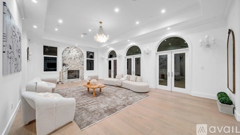 A spacious living room with white furniture and a fireplace.