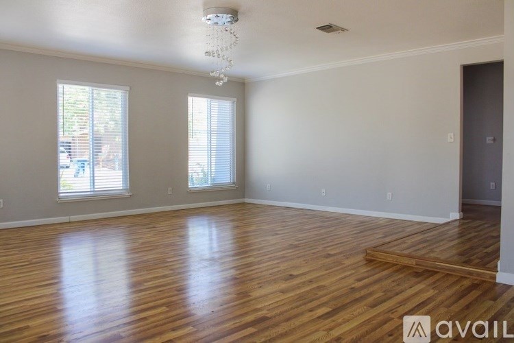 A room with wooden floors and a chandelier.