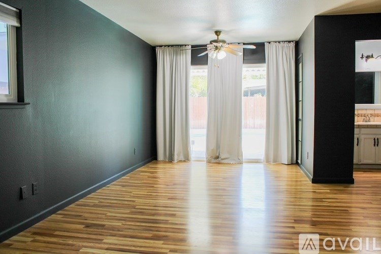 A room with wooden floors and a ceiling fan.