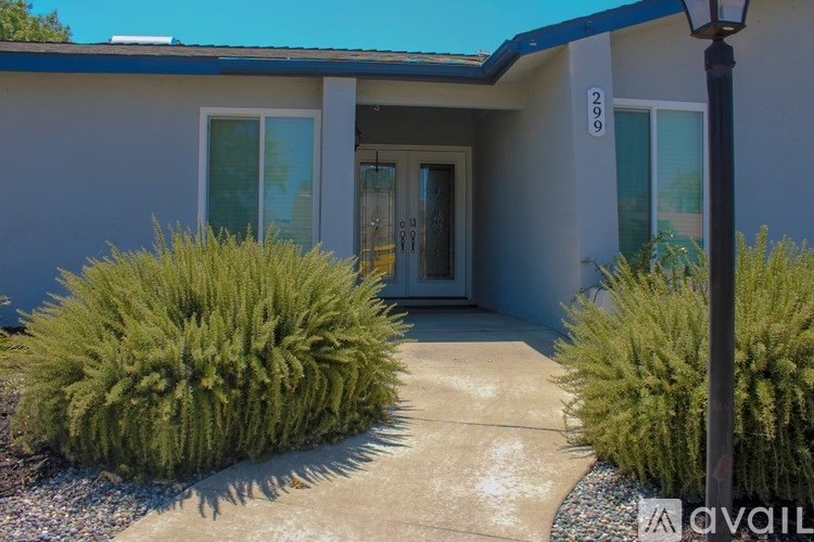 A house numbered 2999 with a brown door and a small garden in front.