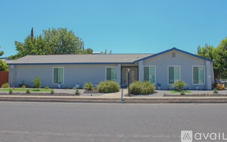 A two-story house with a blue roof and white walls.