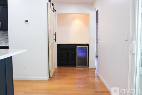 A kitchen with a white counter top and a black cabinet with a stainless steel refrigerator.