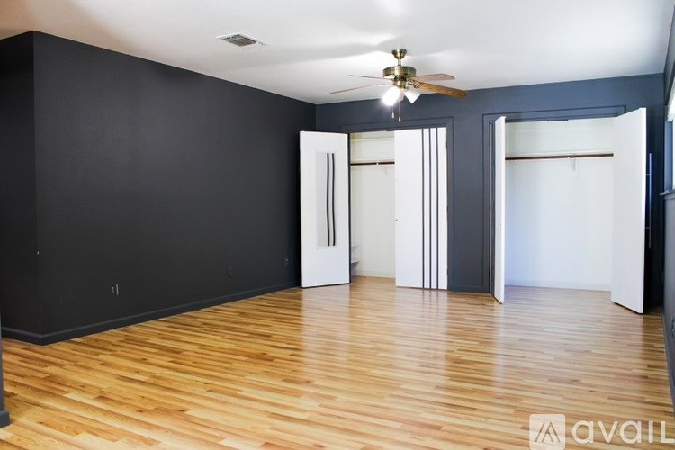 A room with wooden floors and a ceiling fan.