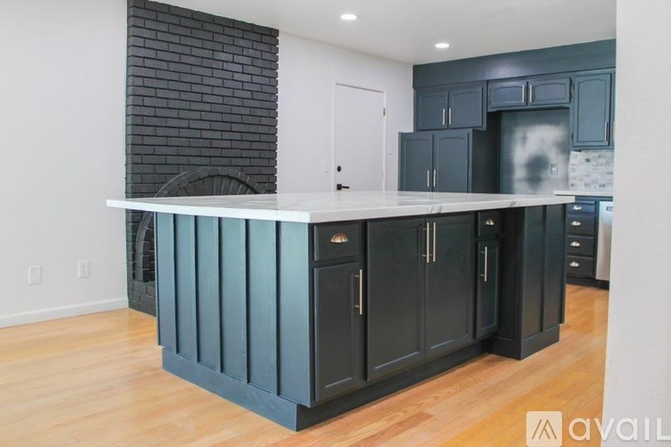 A kitchen with dark cabinets and a white countertop.