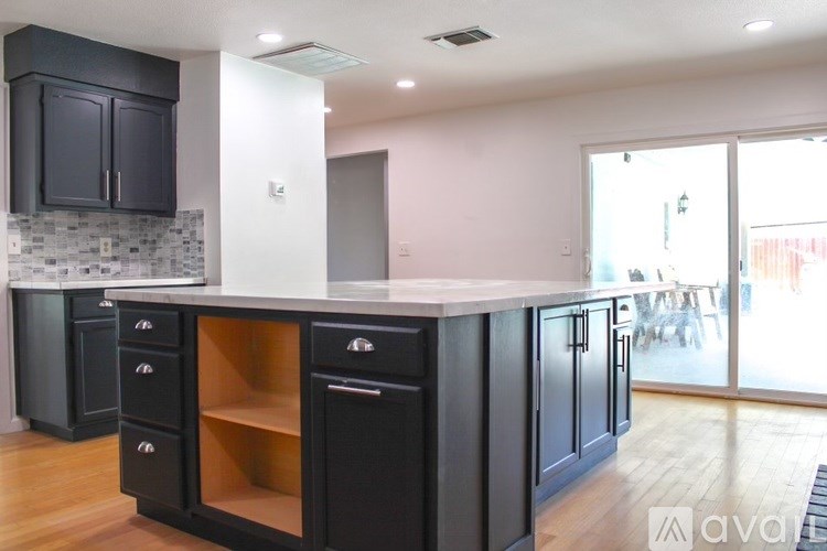 A kitchen with black cabinets and a white countertop.