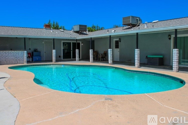 A swimming pool in a backyard with a house in the background.