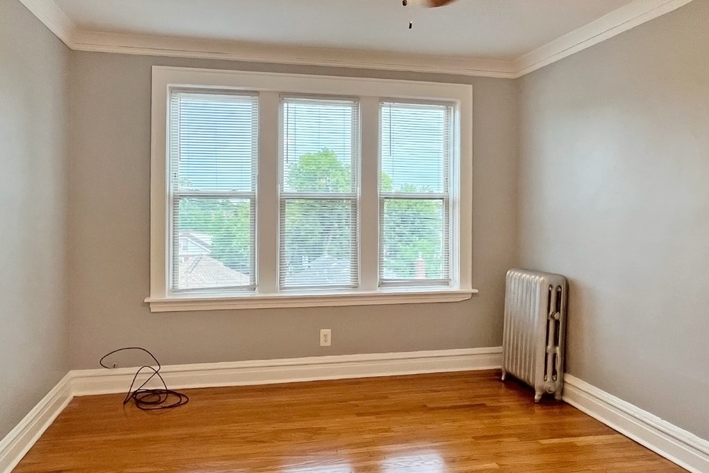 A room with a window and a fan on the ceiling.