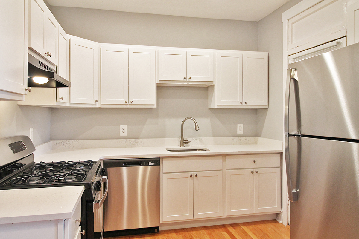 a kitchen with white cabinets and stainless steel appliances