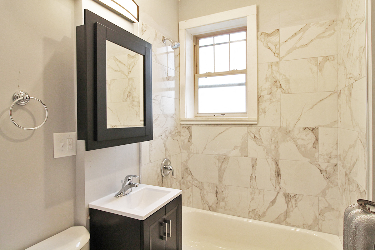 a bathroom with a sink and a bath tub and a window