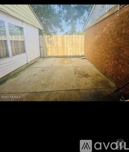 A backyard with a wooden fence and a brick wall.