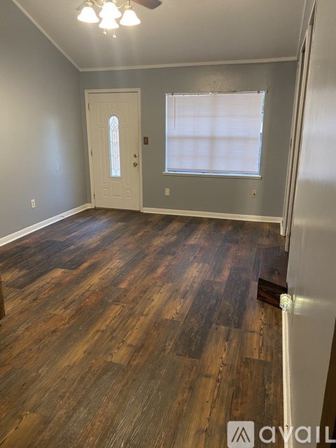 A room with wooden flooring and a white door.