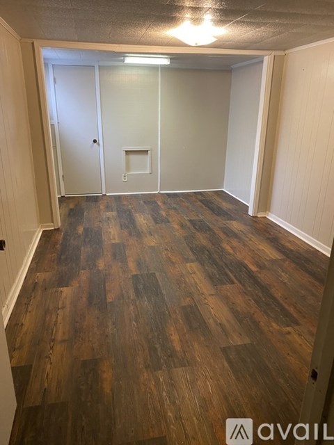 A room with wooden flooring and a white door.