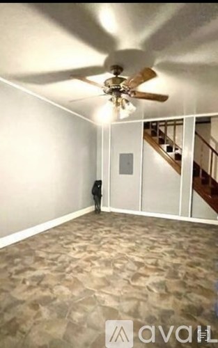 A person standing in a room with a ceiling fan.