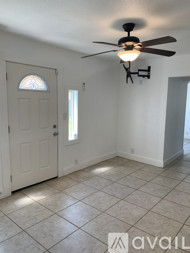 A room with a ceiling fan and tiled floor.