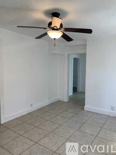 A room with a ceiling fan and tile flooring.