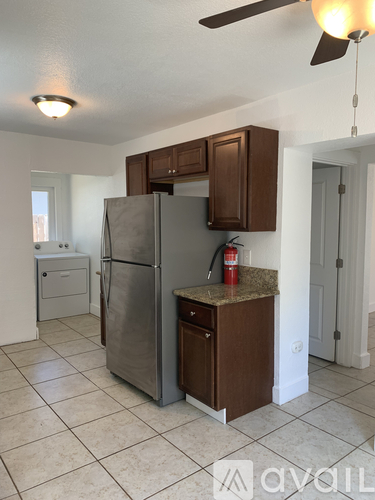 A kitchen with a refrigerator and a fan.