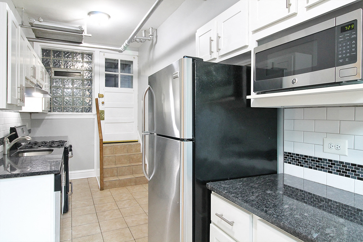a kitchen with stainless steel appliances and white cabinets