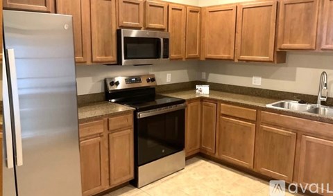 A kitchen with wooden cabinets and stainless steel appliances.