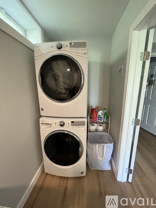 A white washing machine and dryer stacked on top of each other in a laundry room.