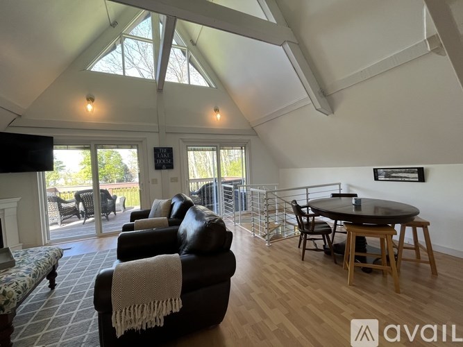 A living room with a black couch and a television.